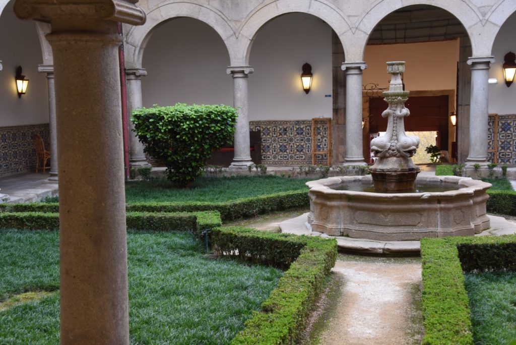 fountain with bushes surrounding it