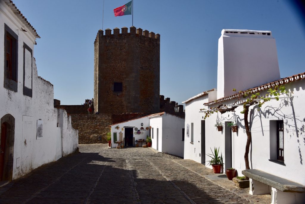 building with flag in the middle of two white buildings