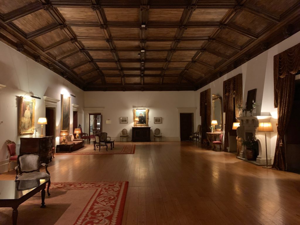 monastery room with carpet, fire place and chairs