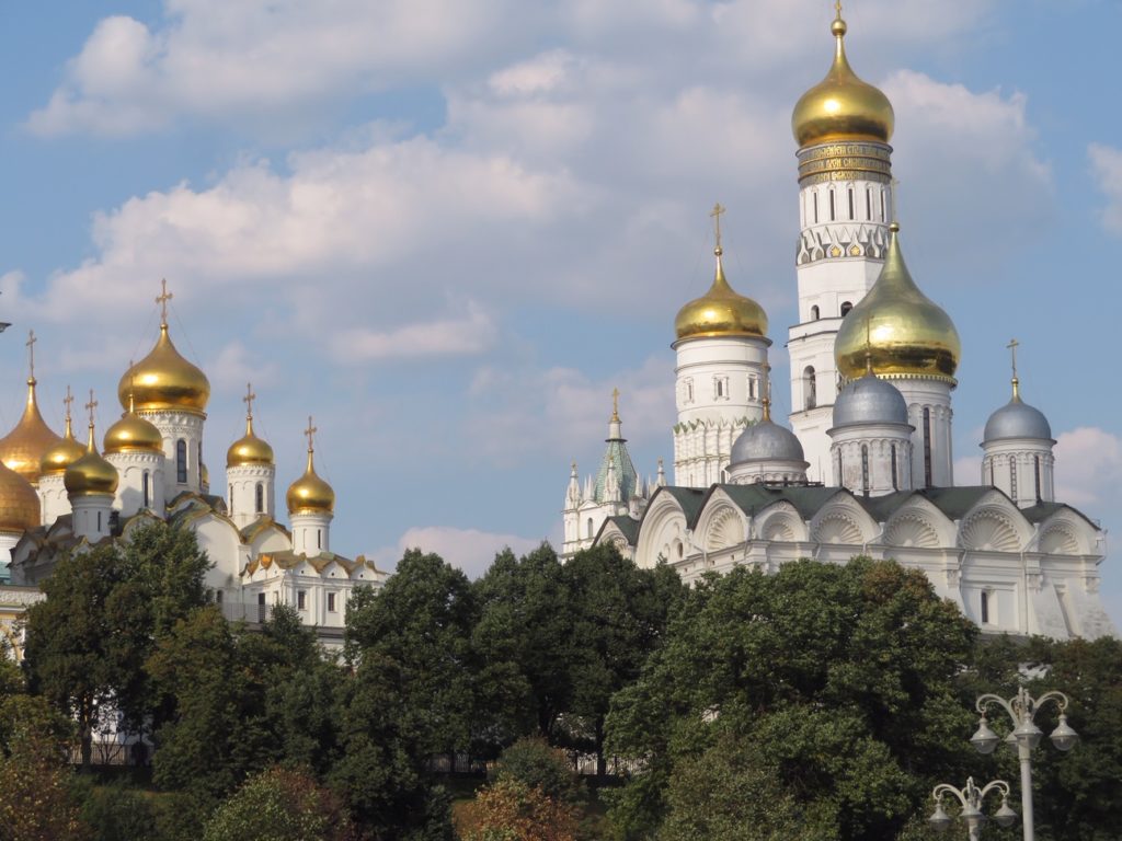 trees and white buildings with gold and silver tops