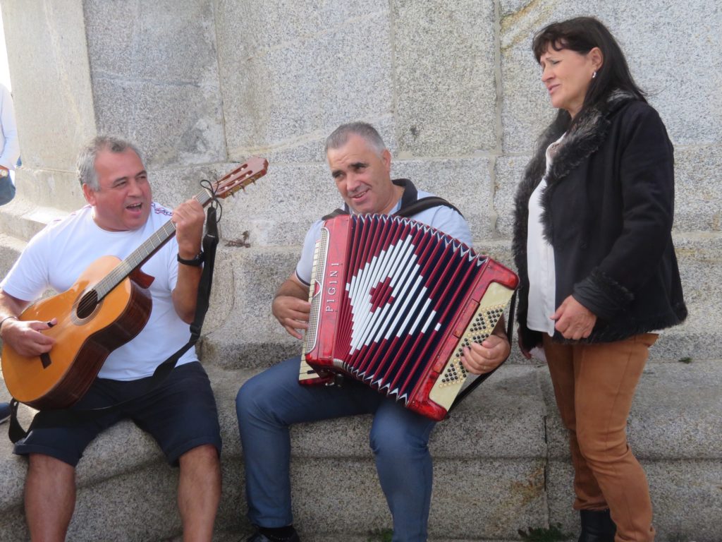 guys playing guitar and Accordion while lady sings